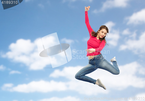 Image of smiling young woman jumping in air