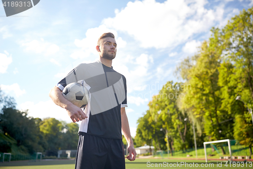 Image of soccer player with ball on football field