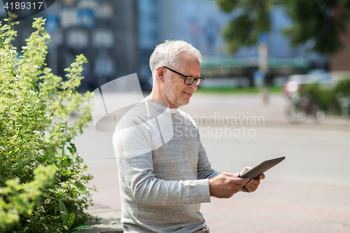 Image of senior man with tablet pc on city street