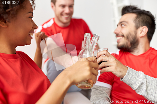 Image of happy football fans or friends with beer at home