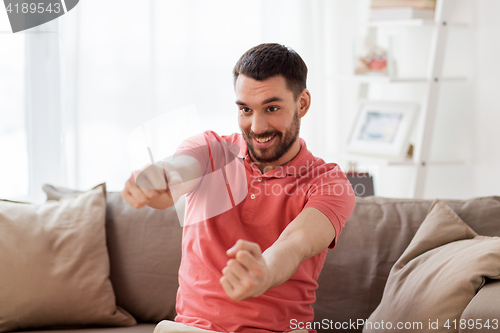 Image of happy man holding something imaginary at home