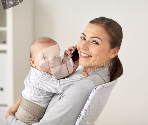 Image of businesswoman with baby and smartphone at office