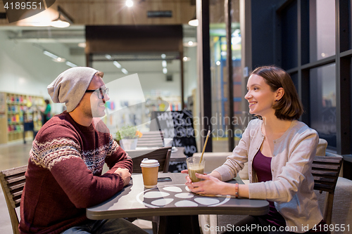 Image of happy couple with coffee and smoothie at cafe