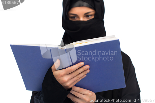 Image of muslim woman in hijab reading book over white