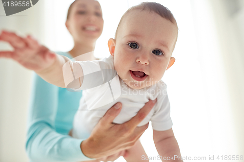 Image of happy young mother with little baby at home