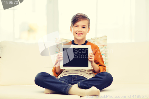 Image of smiling boy with tablet computer at home