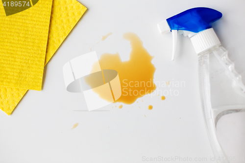 Image of cleaning rag, detergent spray and spilled stain