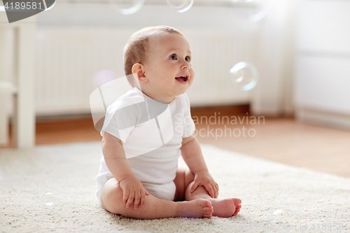 Image of happy baby with soap bubbles at home