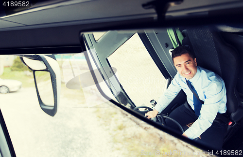 Image of close up of driver reflection in bus mirror