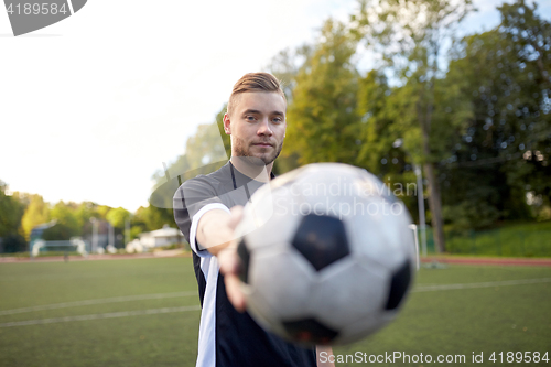 Image of soccer player with ball on football field