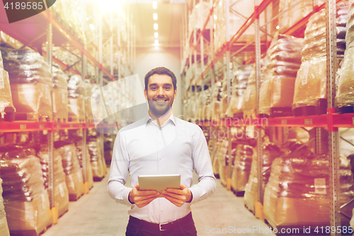 Image of happy businessman with tablet pc at warehouse