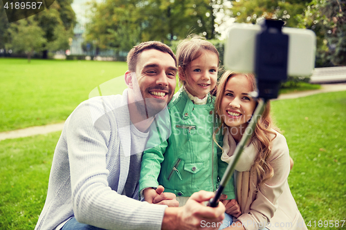 Image of happy family taking selfie by smartphone outdoors