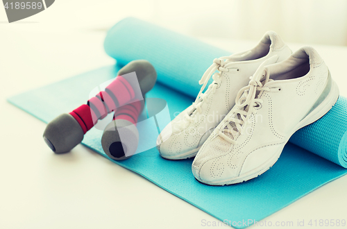 Image of close up of sneakers, dumbbells and sports mat