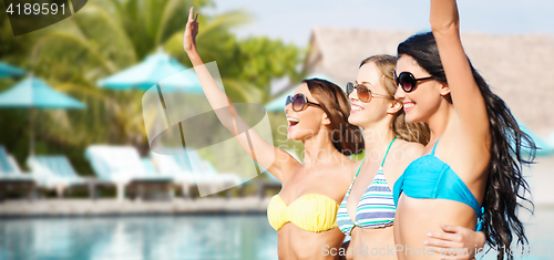 Image of happy young women in bikinis on summer beach