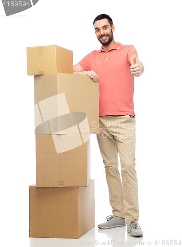 Image of happy man with cardboard boxes showing thumbs up