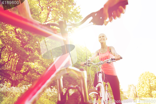 Image of close up of happy couple riding bicycle outdoors