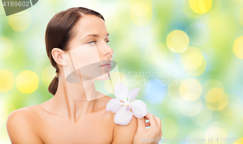 Image of beautiful young woman with orchid flower