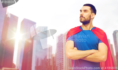 Image of man in red superhero cape over city skyscrapers