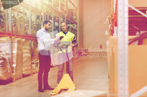 Image of worker and businessmen with clipboard at warehouse