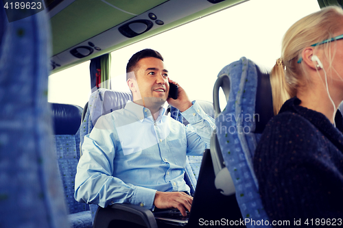 Image of happy man with smartphone and laptop in travel bus