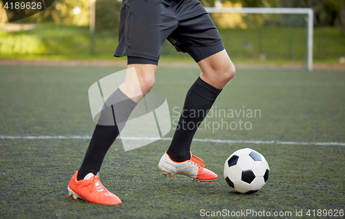 Image of soccer player playing with ball on football field