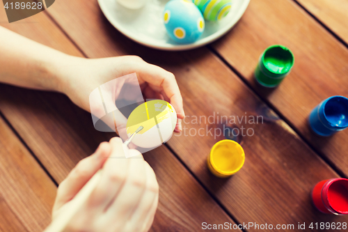 Image of close up of woman hands coloring easter eggs