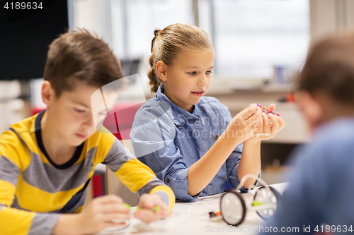 Image of happy children building robots at robotics school