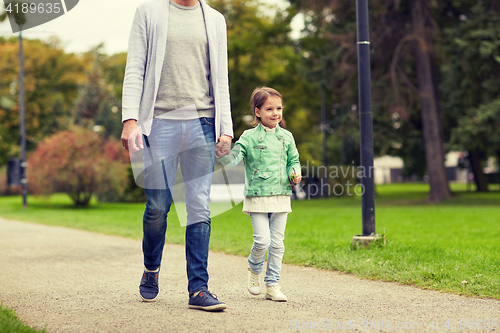 Image of happy family walking in summer park