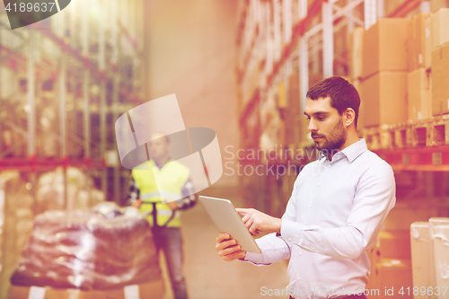 Image of businessman with tablet pc at warehouse