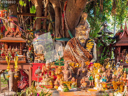 Image of Figurines around a sacred tree in Thailand