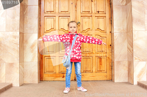 Image of Schoolgirl before big wooden door