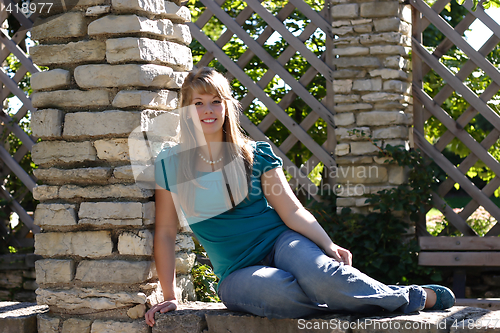 Image of Pretty Teen Girl Sitting on a Wall