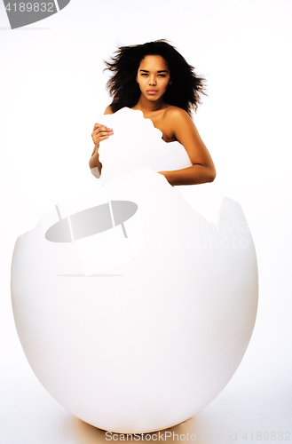 Image of young pretty african american woman in big cracked egg isolated on white background, fashion people concept