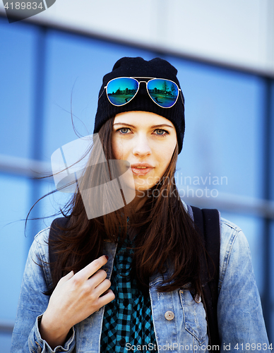 Image of young pretty girl near business building walking