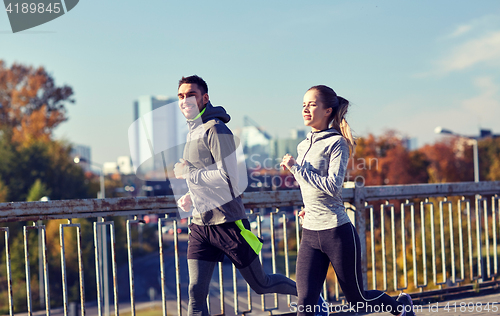 Image of happy couple running outdoors