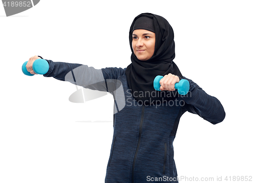 Image of muslim woman in hijab with dumbbells doing fitness