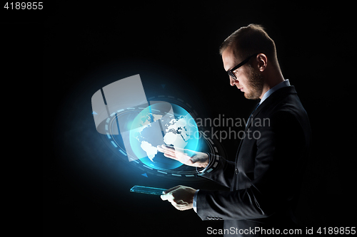 Image of businessman with tablet pc and earth hologram