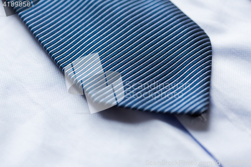 Image of close up of shirt and blue patterned tie