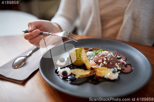 Image of woman eating ice cream dessert at restaurant