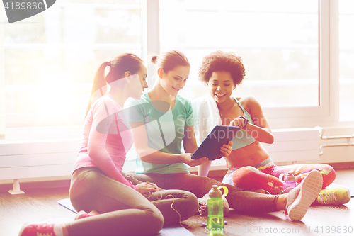 Image of group of happy women with tablet pc in gym