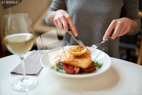 Image of woman eating fish salad at cafe or restaurant