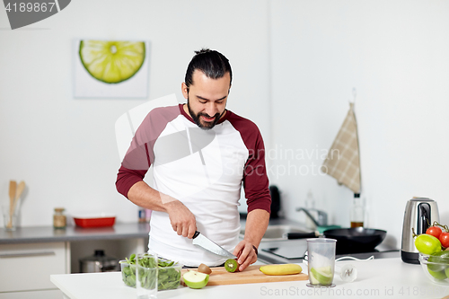 Image of man with blender and fruit cooking at home kitchen