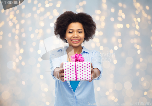 Image of happy african woman with birthday gift box