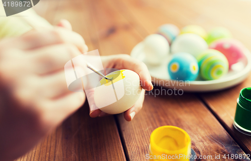 Image of close up of woman hands coloring easter eggs