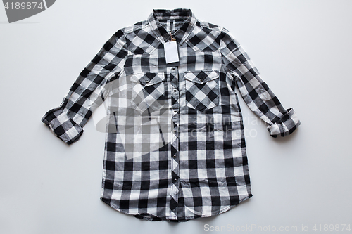 Image of checkered shirt with price tag on white background