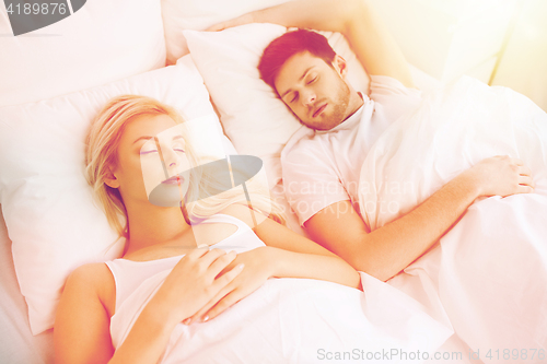 Image of happy couple sleeping in bed at home