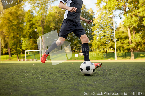 Image of soccer player playing with ball on football field