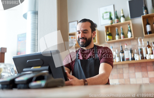 Image of happy man or waiter at bar cashbox