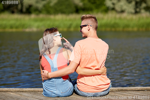 Image of happy teenage couple hugging on river summer berth