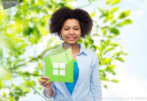 Image of happy african american woman with green house icon